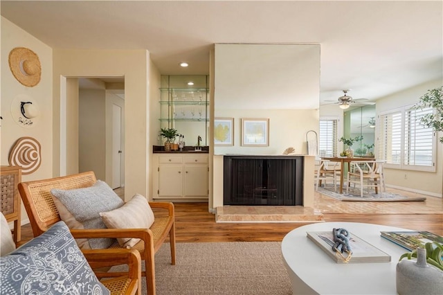 interior space featuring ceiling fan, sink, and light wood-type flooring