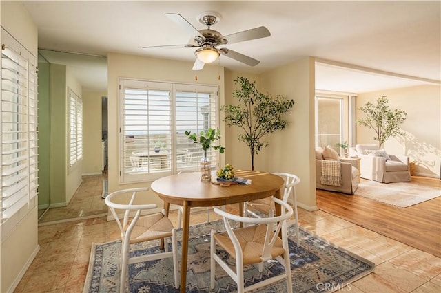 tiled dining space featuring ceiling fan