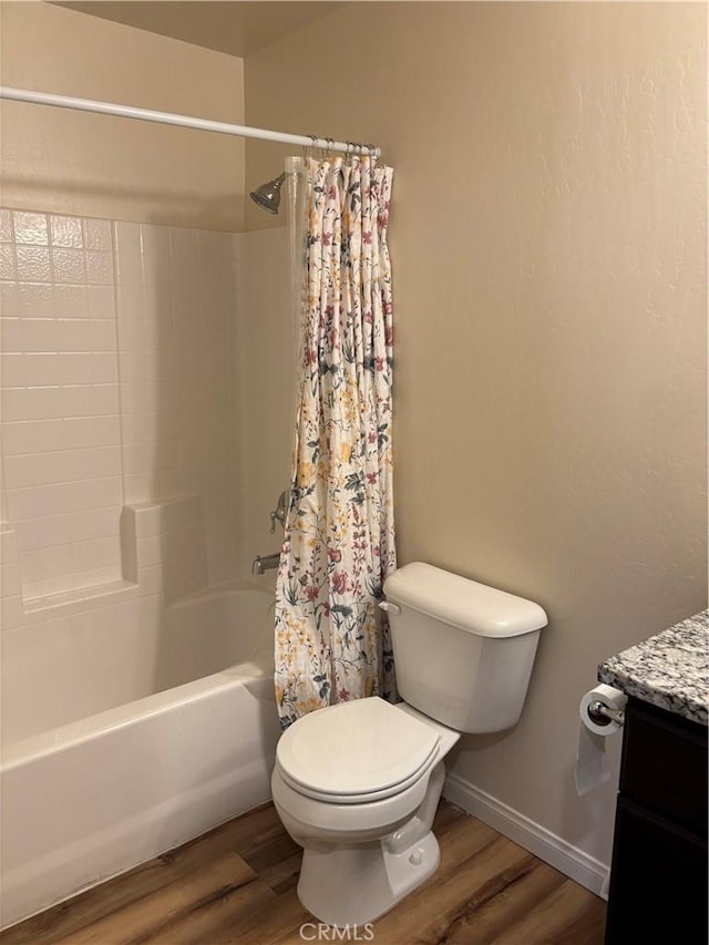 full bathroom with wood-type flooring, toilet, shower / bath combo with shower curtain, and vanity