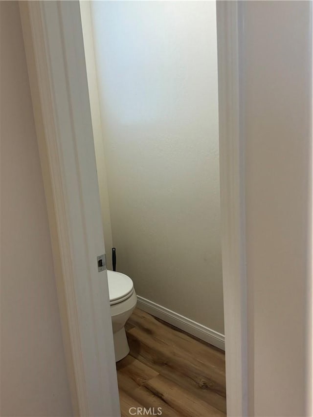 bathroom with hardwood / wood-style flooring and toilet