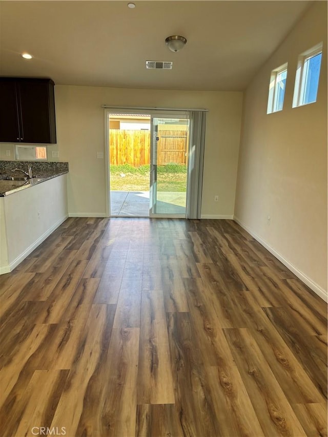 unfurnished living room with dark hardwood / wood-style floors and sink