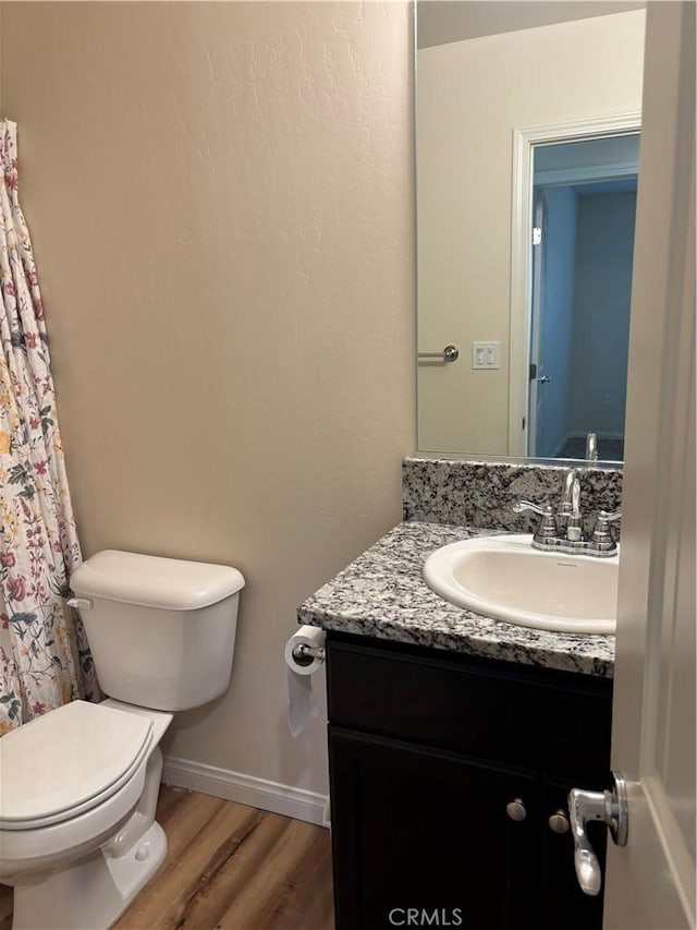 bathroom with vanity, hardwood / wood-style flooring, and toilet