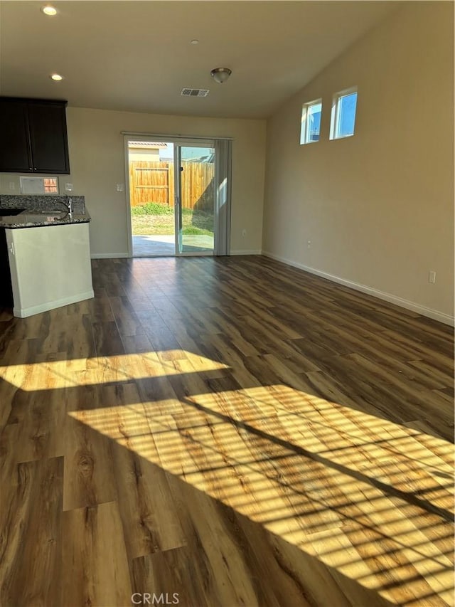 unfurnished living room with lofted ceiling and dark hardwood / wood-style floors