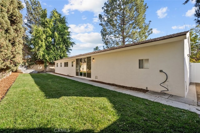 rear view of property with a yard