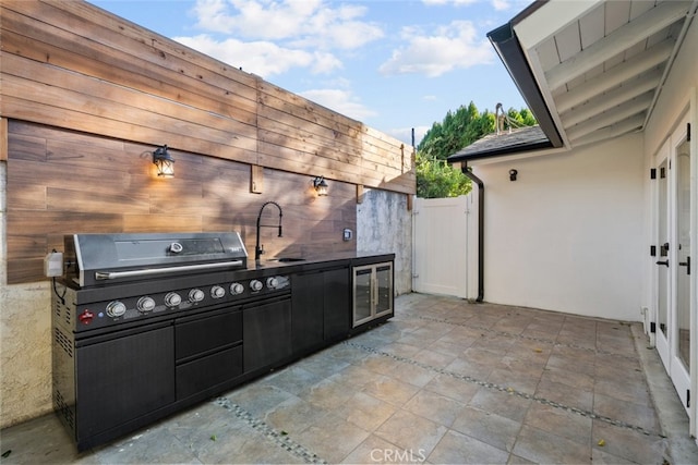 view of patio / terrace with an outdoor kitchen, sink, wine cooler, and grilling area