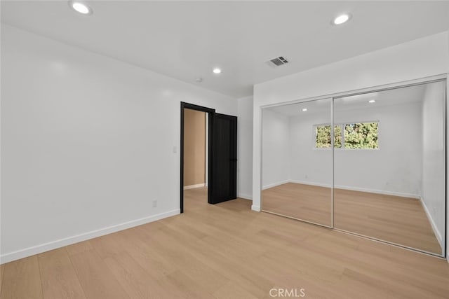 unfurnished bedroom with light hardwood / wood-style floors and a closet