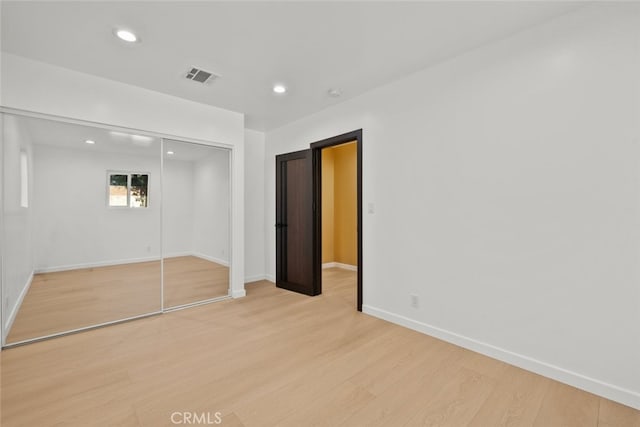 unfurnished bedroom with light hardwood / wood-style floors and a closet