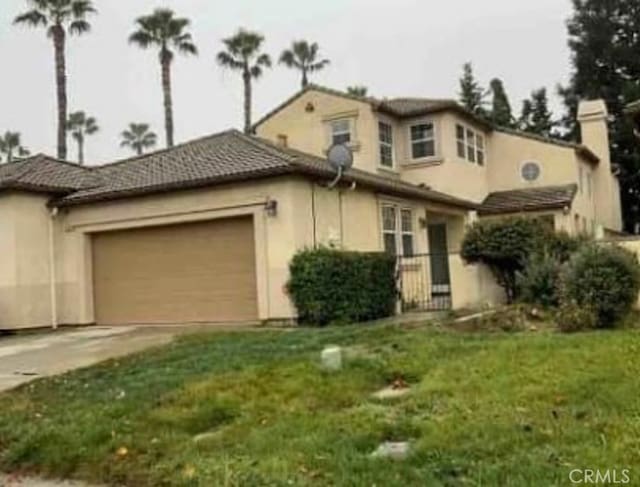 view of front of house with a garage and a front lawn