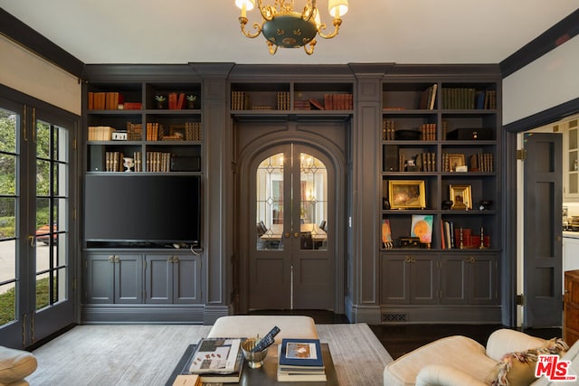 interior space with hardwood / wood-style flooring, ornamental molding, a notable chandelier, and french doors