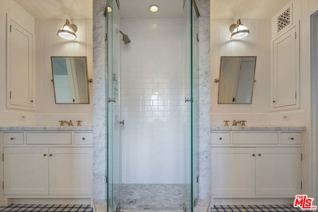 bathroom with vanity and a shower with door