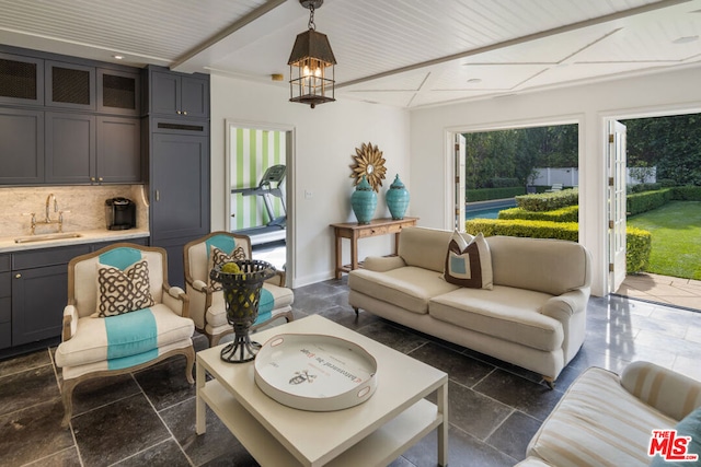 living room featuring beam ceiling and sink