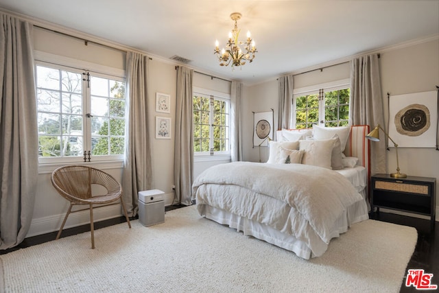 bedroom featuring crown molding and a chandelier