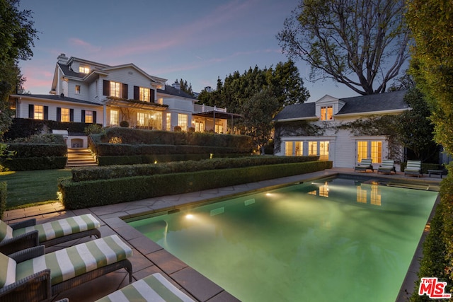 pool at dusk with a patio