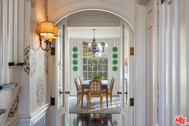 dining room with hardwood / wood-style flooring, a notable chandelier, and french doors