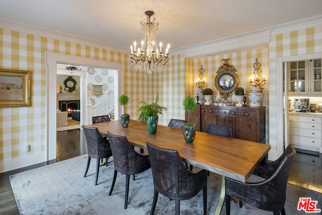 dining room with an inviting chandelier, crown molding, and dark wood-type flooring