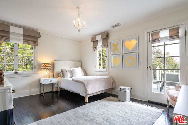 bedroom with dark hardwood / wood-style flooring, access to outside, and a chandelier