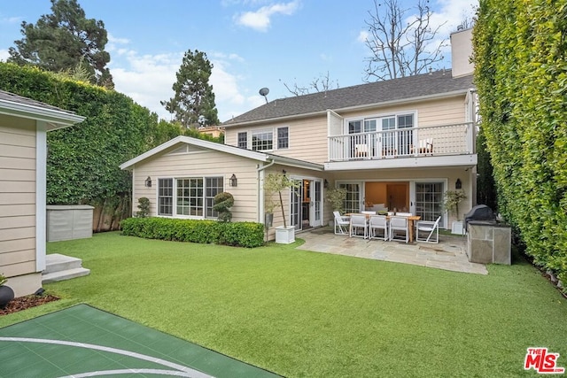 back of property featuring a patio, a balcony, and a yard