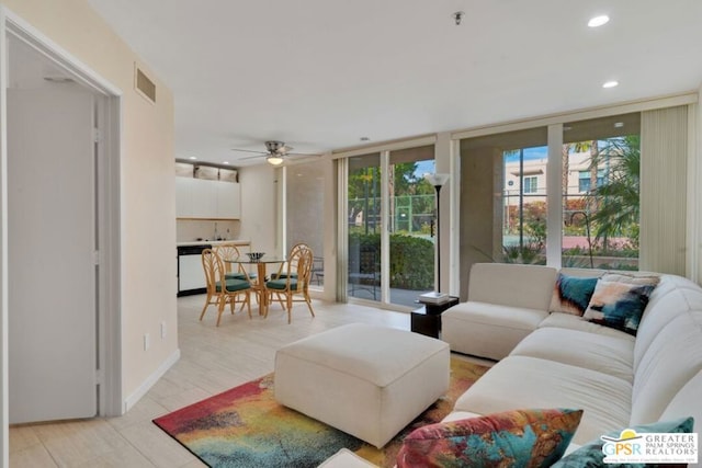 living room with expansive windows and ceiling fan