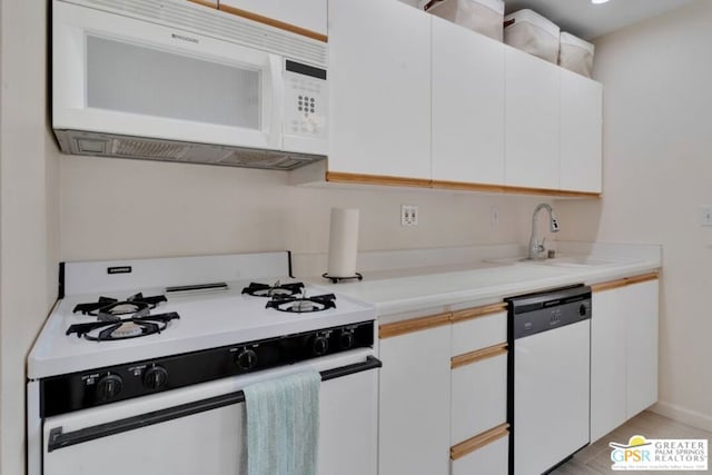 kitchen featuring white cabinetry, sink, and white appliances