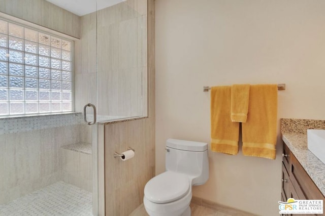 bathroom with a shower with door, vanity, and toilet