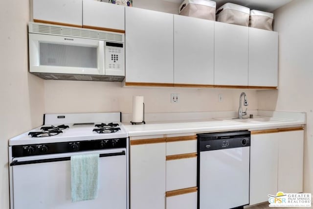 kitchen with sink, white appliances, and white cabinets