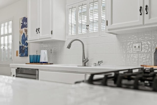 kitchen featuring tasteful backsplash and white cabinets