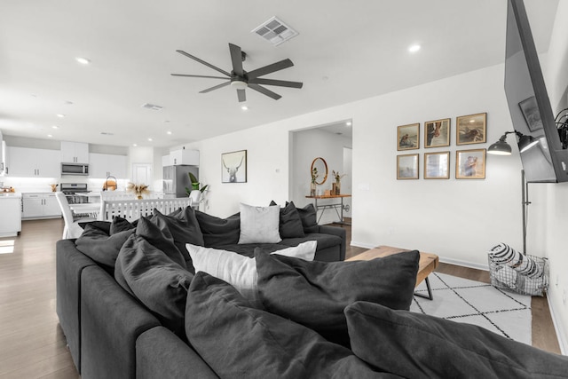 living room with ceiling fan and light hardwood / wood-style floors