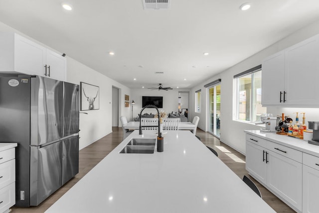 kitchen featuring sink, stainless steel fridge, dark hardwood / wood-style flooring, ceiling fan, and white cabinets