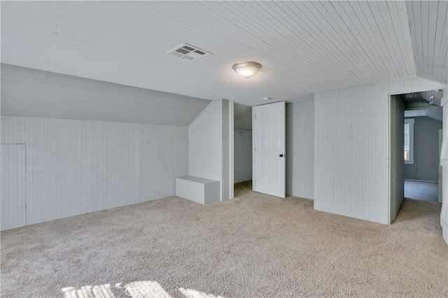 bonus room with lofted ceiling and light carpet