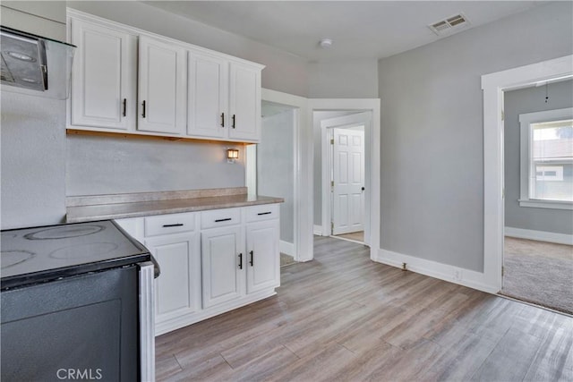 kitchen with range with electric cooktop, light wood-type flooring, and white cabinets