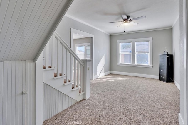 interior space with ceiling fan, ornamental molding, a healthy amount of sunlight, and carpet