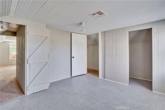 unfurnished bedroom with vaulted ceiling, carpet flooring, ceiling fan, and a closet