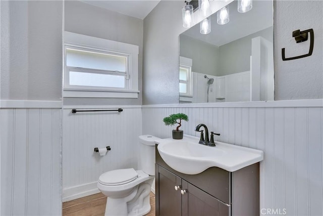 bathroom with vanity, hardwood / wood-style floors, toilet, and a shower