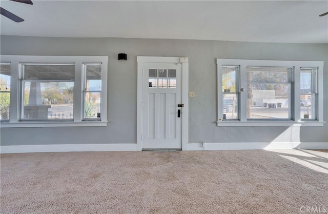 entryway with ceiling fan and carpet flooring