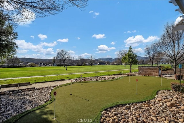 view of property's community featuring a lawn and a mountain view