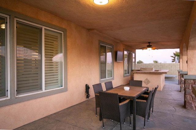 view of patio with exterior bar and ceiling fan