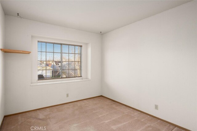 unfurnished room featuring light carpet