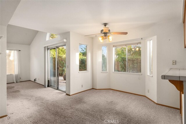 unfurnished living room featuring lofted ceiling, light colored carpet, and ceiling fan