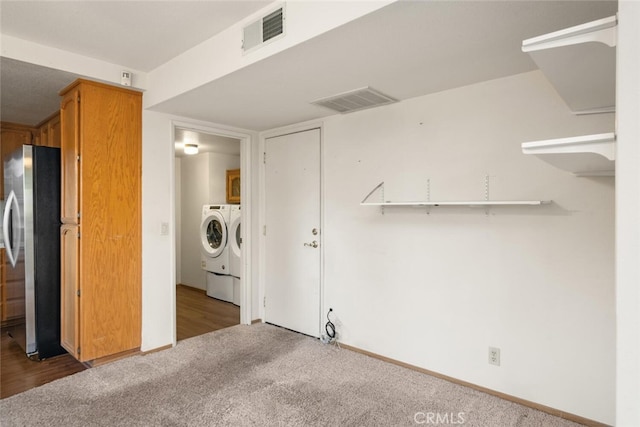 clothes washing area with independent washer and dryer and carpet