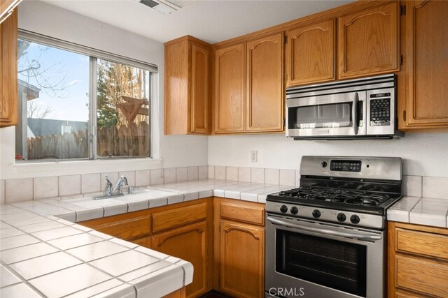 kitchen with tile countertops and stainless steel appliances