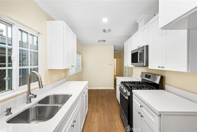 kitchen with white cabinetry, sink, and appliances with stainless steel finishes