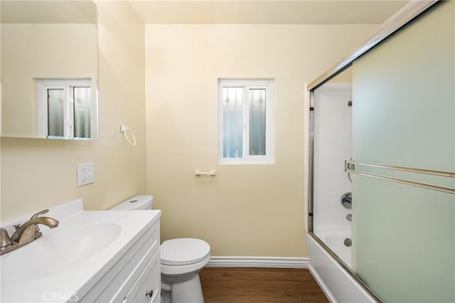 full bathroom featuring enclosed tub / shower combo, hardwood / wood-style floors, vanity, and toilet