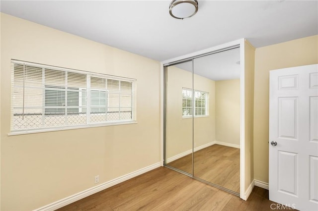 unfurnished bedroom featuring hardwood / wood-style floors and a closet