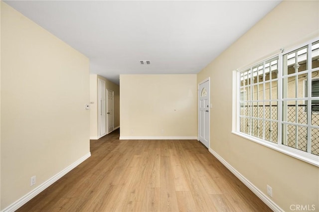 empty room with light hardwood / wood-style flooring