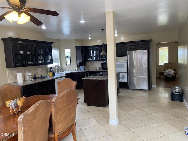 kitchen featuring tasteful backsplash, appliances with stainless steel finishes, plenty of natural light, and light tile patterned floors