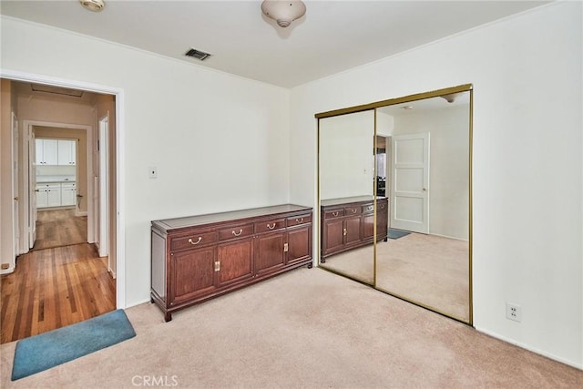 unfurnished bedroom featuring light carpet and a closet