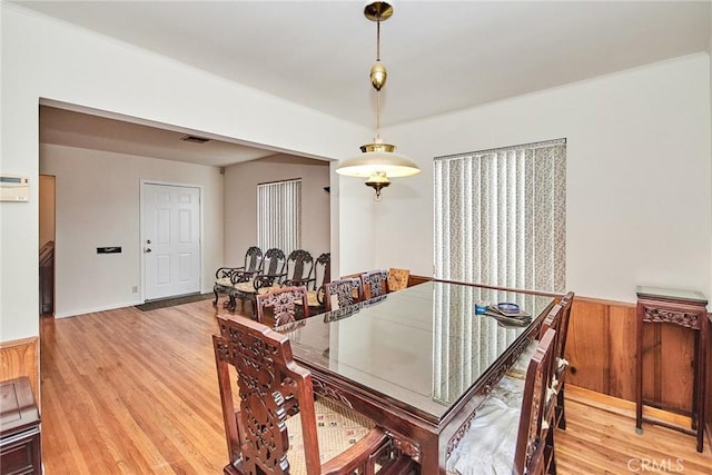 dining room featuring hardwood / wood-style floors and wooden walls