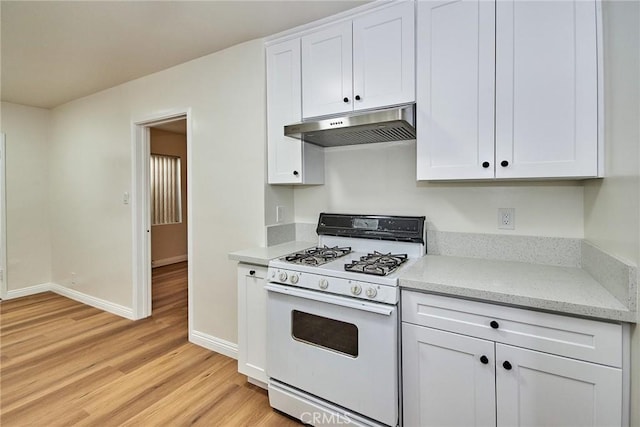 kitchen featuring white cabinetry, white range with gas cooktop, light stone counters, and light wood-type flooring