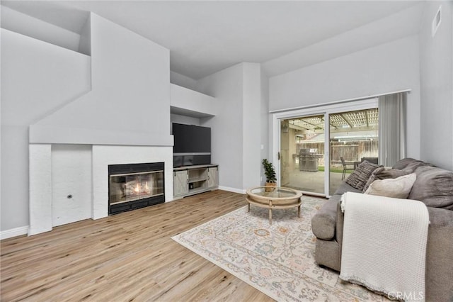 living room with vaulted ceiling and light wood-type flooring