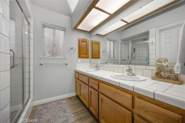 bathroom with hardwood / wood-style flooring, vanity, a shower with door, and a wealth of natural light